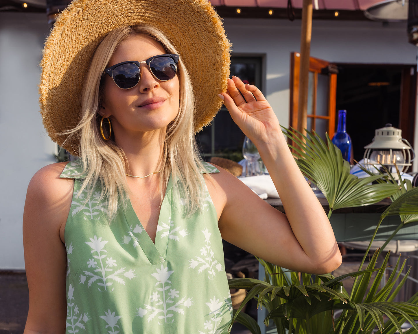 girl in green silk dress wearing hat and sunglasses